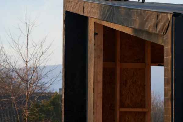 A master builder drilling and nailing the iron sheet.