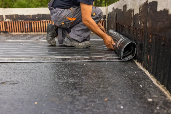 A male worker laying the coated seal for the roof leakage.