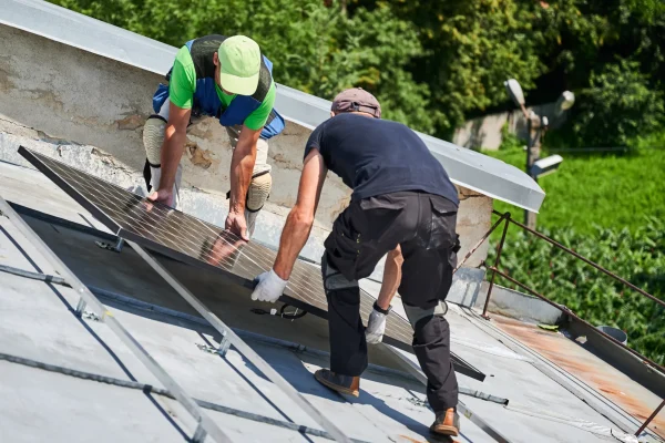 Workers installing the solar panel on the roof.
